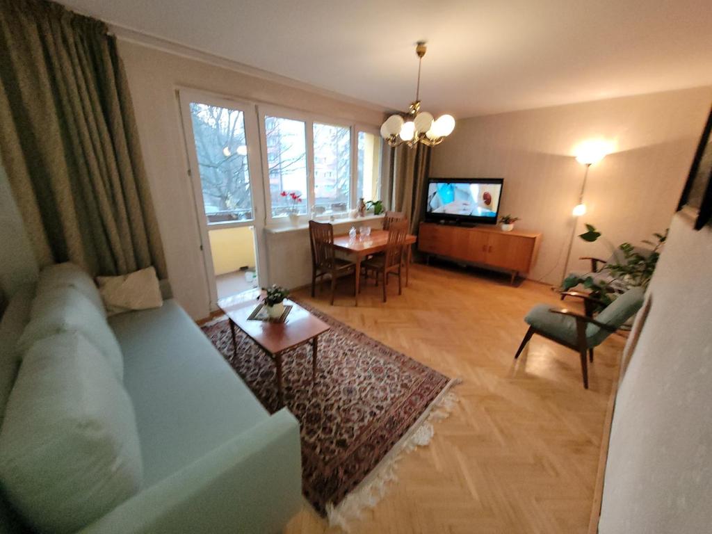 a living room with a couch and a dining room at MY SUITE 60th in Gdańsk