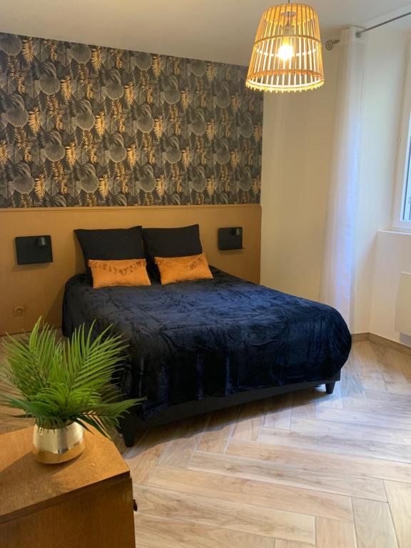 ein Schlafzimmer mit einem Bett und einer Topfpflanze in der Unterkunft F2 Rez de Chaussée Ô meublé de Pithiviers in Pithiviers