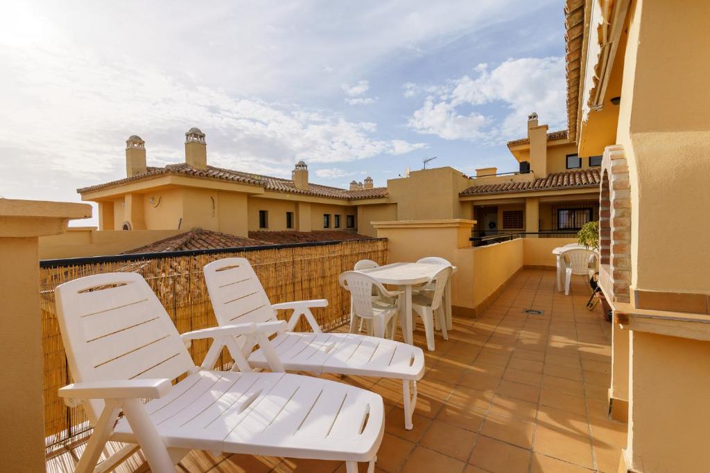 patio z białymi krzesłami i stołami na balkonie w obiekcie CT 139 - Cumbres de Riviera - Penthouse w mieście Mijas Costa