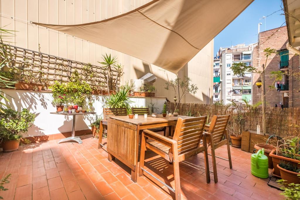 an outdoor patio with a wooden table and chairs at Apartment Vallhonrat in Barcelona