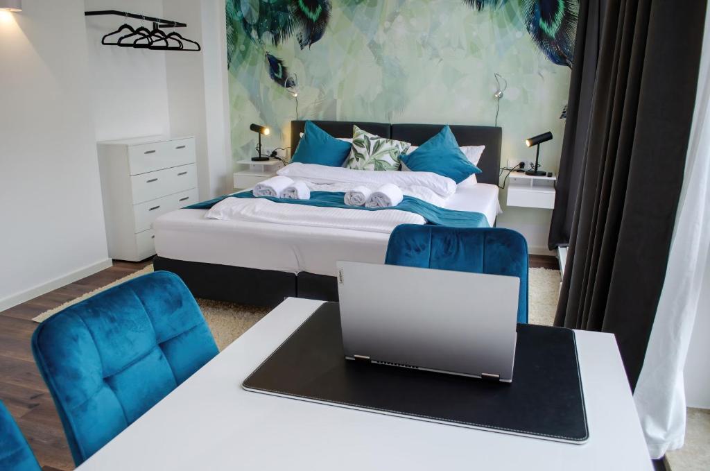 Schlafzimmer mit einem Bett und einem Laptop auf einem Schreibtisch in der Unterkunft HOMELY STAY Studio 6 in München
