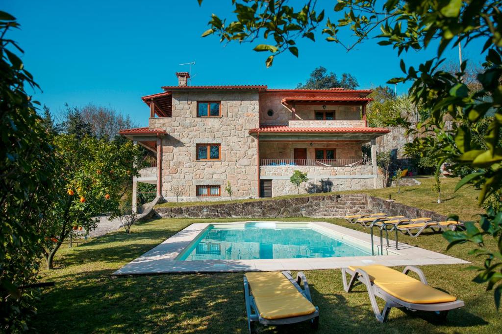 una casa con piscina frente a una casa en Casa das Flores en Amares