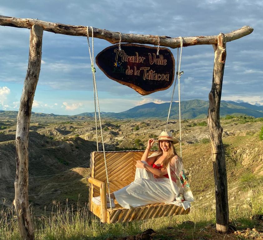 une femme assise sur une balançoire dans les montagnes dans l'établissement Mirador Valle de la Tatacoa, à Villavieja