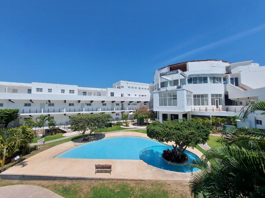 a large building with a swimming pool in front of it at Casa Blanca Grand in Acapulco