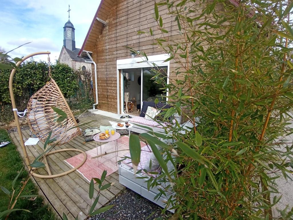 une terrasse en bois avec une chaise et une table dans l'établissement Maison familiale à la campagne, à La Chapelle-du-Bourgay