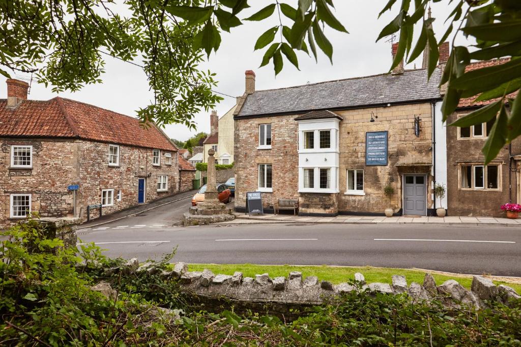 an empty street in a village with stone buildings at The Cross at Croscombe in Wells