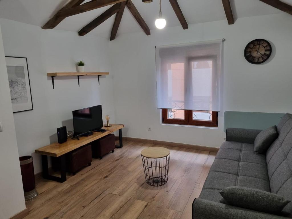 ein Wohnzimmer mit einem Sofa und einem TV in der Unterkunft 119D2 Apartamento con encanto en pleno centro in Gijón