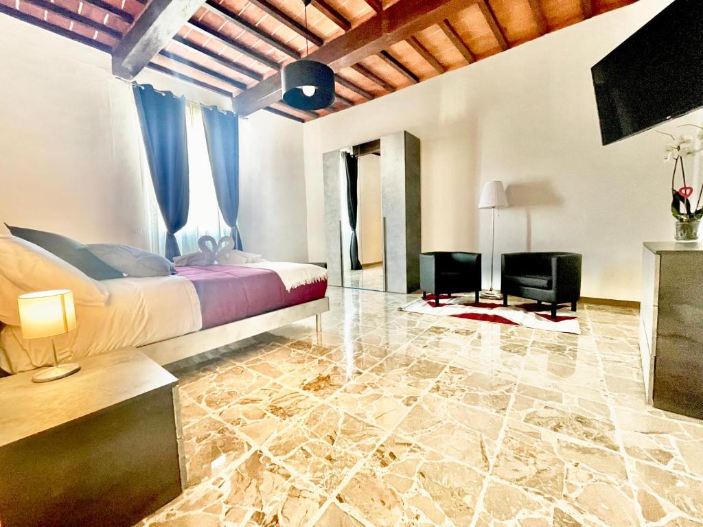 Il Barbero Apartment في سيينا: غرفة نوم بسرير وتلفزيون في غرفة