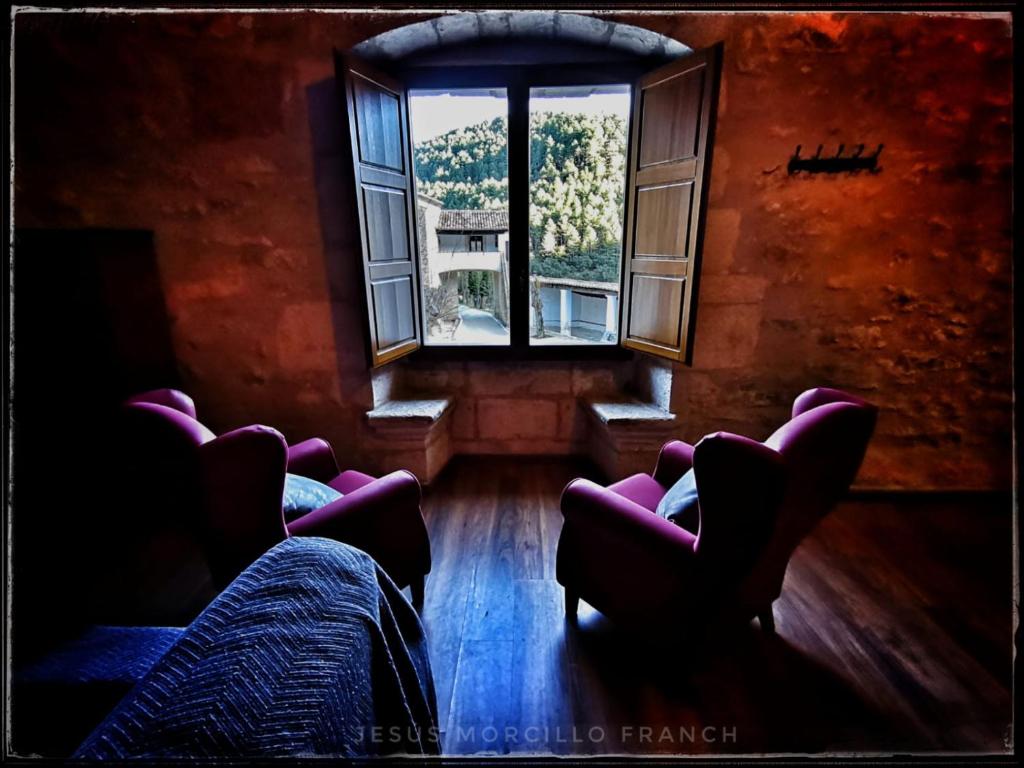 um quarto com cadeiras e uma grande janela em Casa Els Arcs em Castellfort
