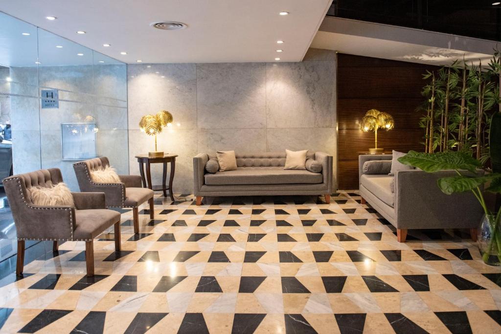 a lobby with couches and chairs on a checkered floor at Grand King Hotel in Buenos Aires