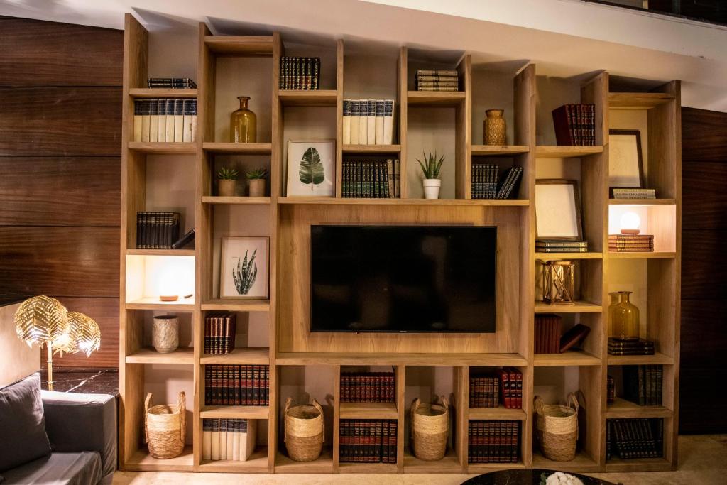 a living room with a tv in a book shelf at Grand King Hotel in Buenos Aires