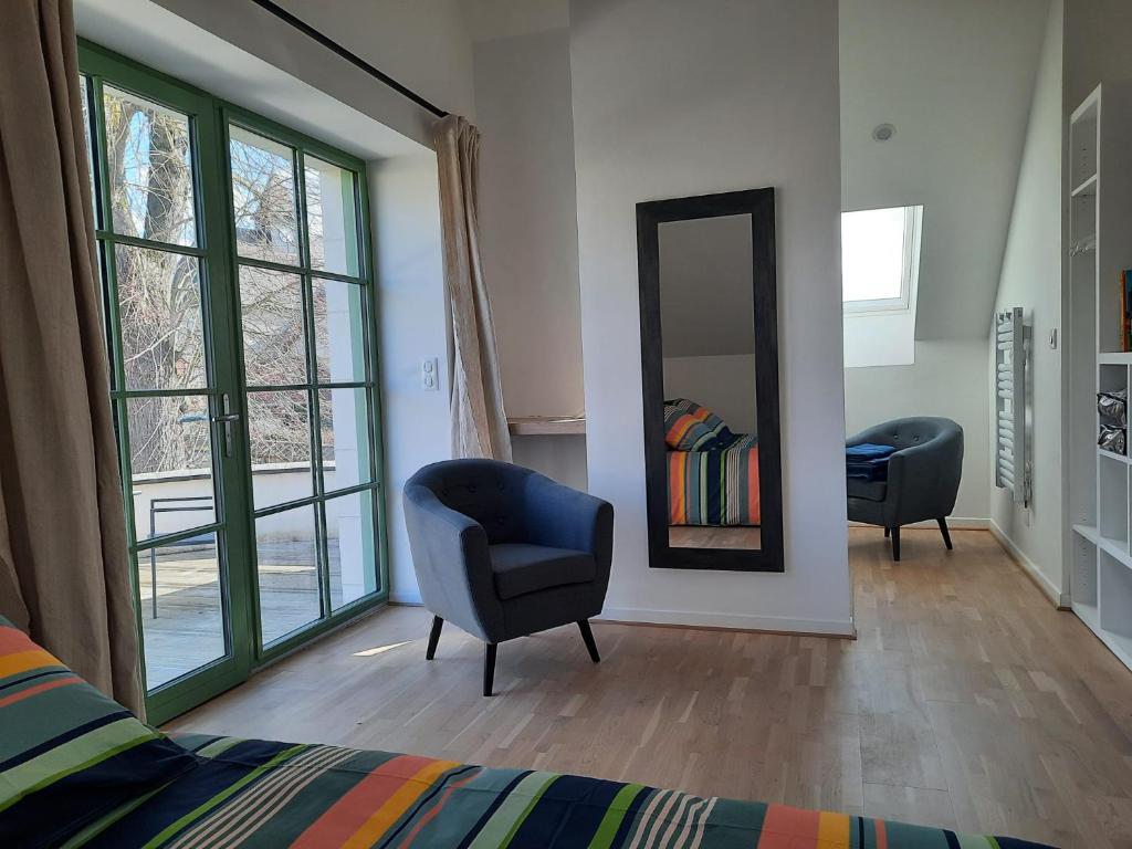 RévillonにあるLE RELAISのベッドルーム(鏡、椅子、ベッド付)