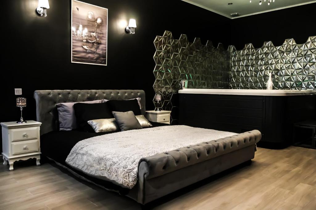 um quarto com uma cama com uma parede preta em Velezia LOVE em Roujan