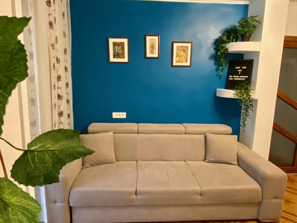 a couch in a living room with a blue wall at Serene Apartment Navodari in Năvodari