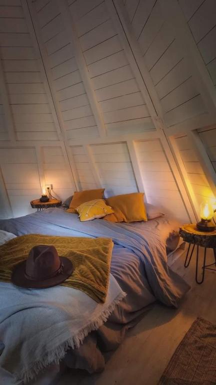 un sombrero sentado en una cama en una habitación en Glamping The Teepee, en Mombeltrán