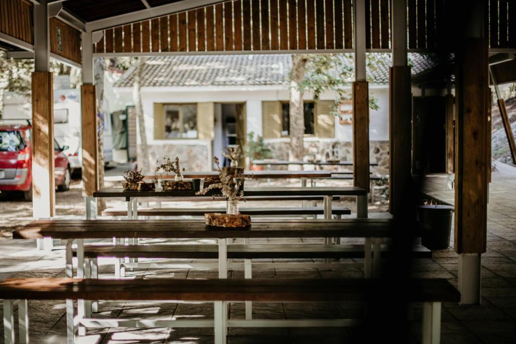 una fila de bancos de madera frente a un edificio en Glamping The Teepee en Mombeltrán