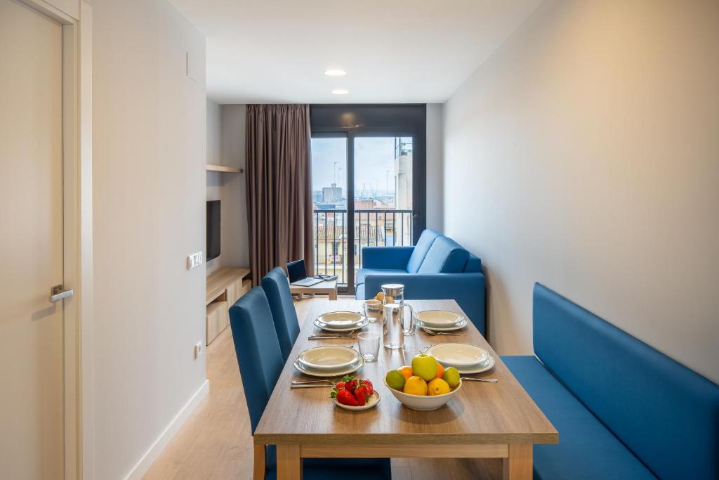uma sala de jantar com uma mesa e cadeiras azuis em Tgna Rambla 68 em Tarragona