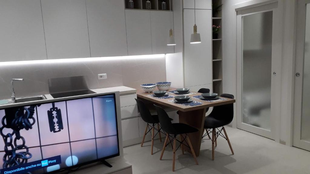 a kitchen with a small table with chairs and a tv at RESIDENZA CORSO DALMAZIA in Civitanova Marche