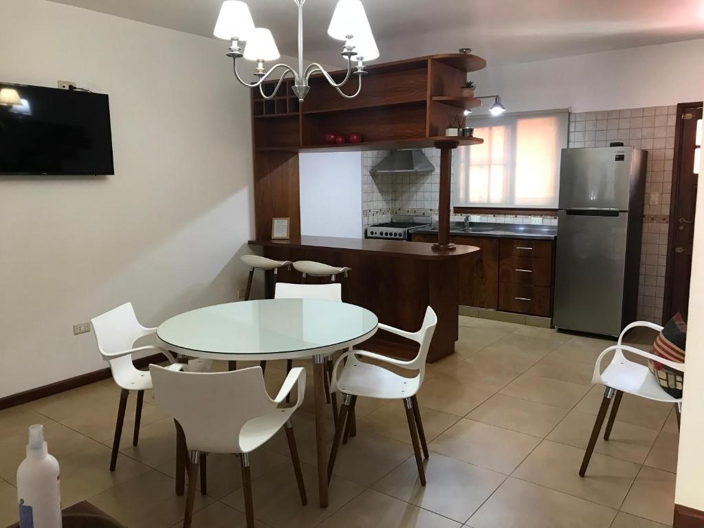 La cuisine est équipée d'une table, de chaises et d'un réfrigérateur. dans l'établissement Duplex Salvat, à Puerto Iguazú