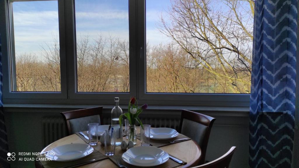 una mesa en un restaurante con dos ventanas en Schöne und gemütliche Wohnung en Bremen
