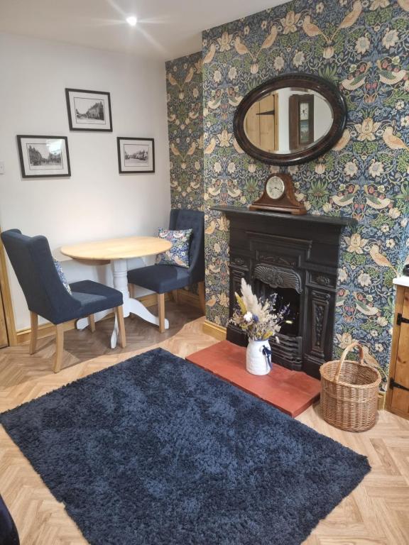 uma sala de estar com lareira e espelho em Cosy Cottage, in the idyllic town of Holt em Holt