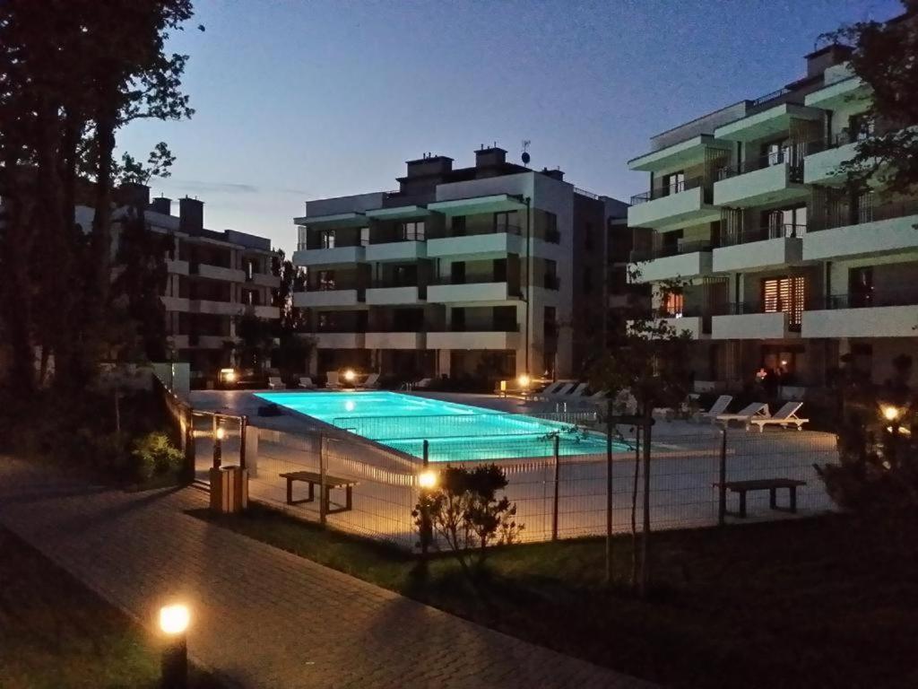 een groot zwembad voor een gebouw bij Apartament Szprotka in Ustronie Morskie
