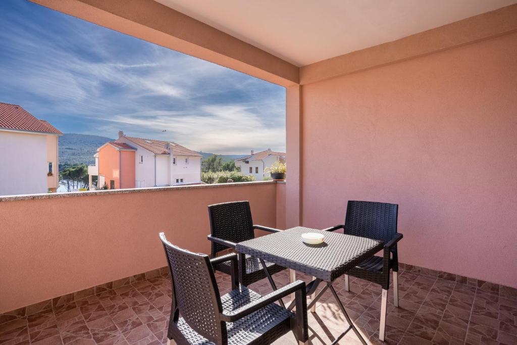 a patio with a table and chairs on a balcony at Apartment Brđanović in Cres