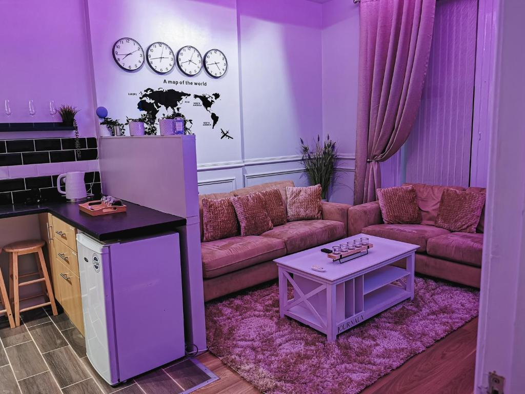 uma sala de estar roxa com um sofá e uma mesa em LUXURIOUS 3 BEDROOM APARTMENT: HEART OF WESTEND em Glasgow