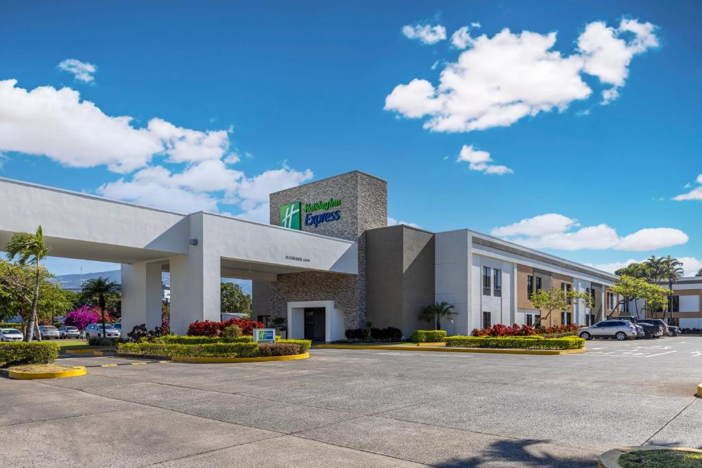 a large office building with a parking lot at Holiday Inn Express San Jose Costa Rica Airport by IHG in Alajuela City