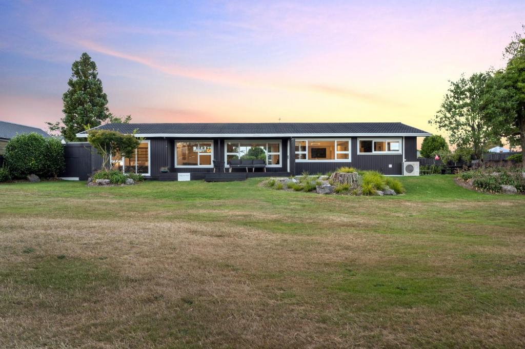 una casa negra con un gran patio en Above Par Golf Course Villa with Hot Tub 4bd3bth, en Rotorua
