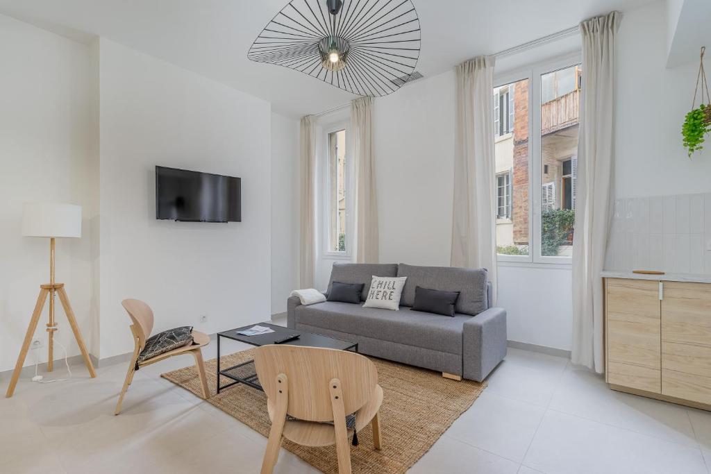 un salon blanc avec un canapé et une télévision dans l'établissement Spacieux T3 climatisé - Saint Charles & Vieux Port, à Marseille