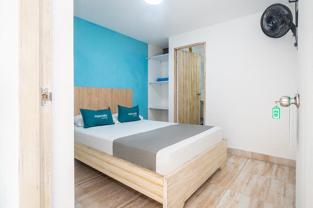1 dormitorio con 1 cama con paredes azules en Ayenda Malaki en Medellín