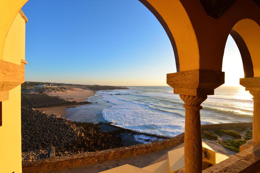 a view of the ocean from a window of a building at Hotel Fortaleza do Guincho Relais & Châteaux in Cascais