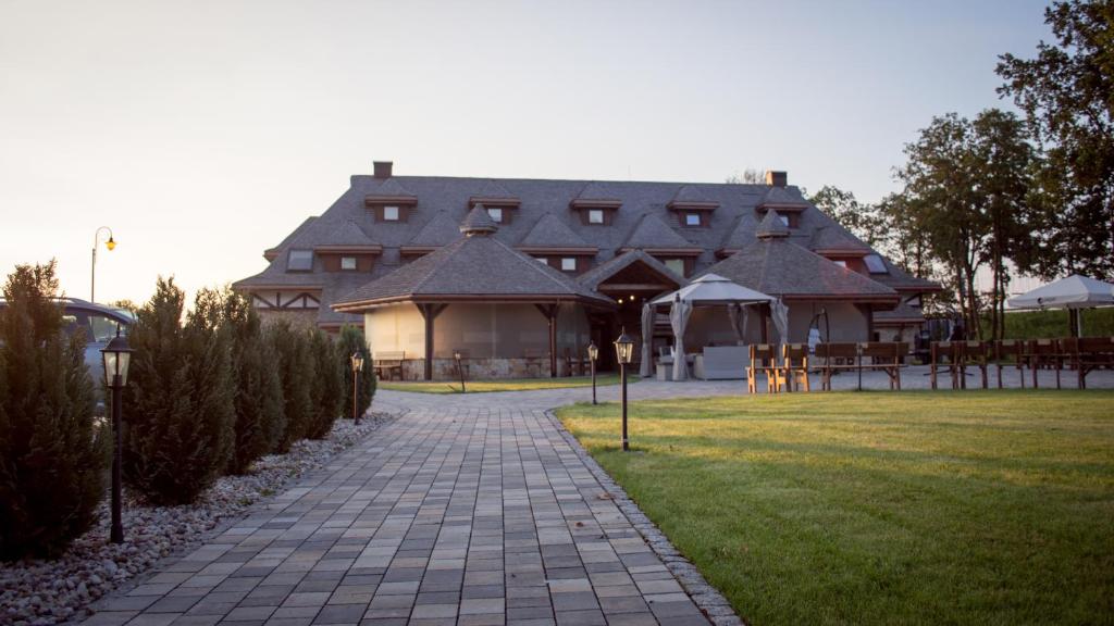 a large house with a walkway in front of it at Hotel & Spa **** Kasztel Uniejów in Uniejow