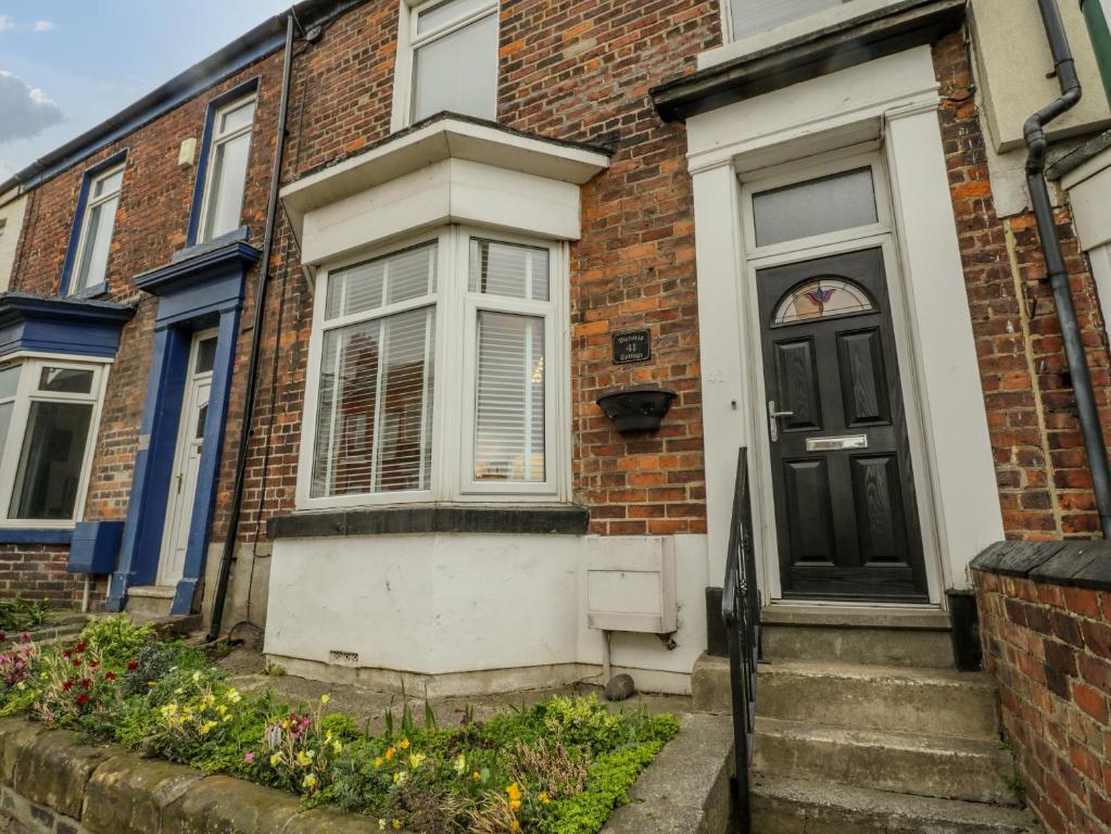 a brick house with a black door at Victoria Cottage in Redcar