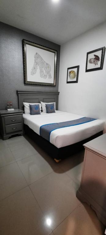 um quarto com uma cama grande e almofadas azuis em Smart Tlogomas Syariah em Malang