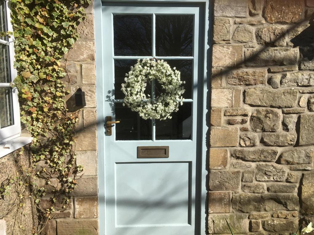 Una puerta blanca con una corona. en 2 Redeswood Cottages, en Bellingham