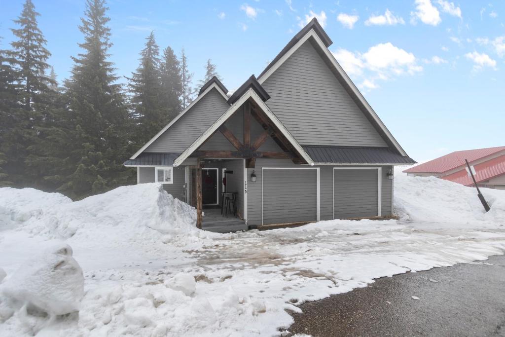 Una casa en la nieve con nieve alrededor. en Slalom Run Mountain Home, en Sandpoint
