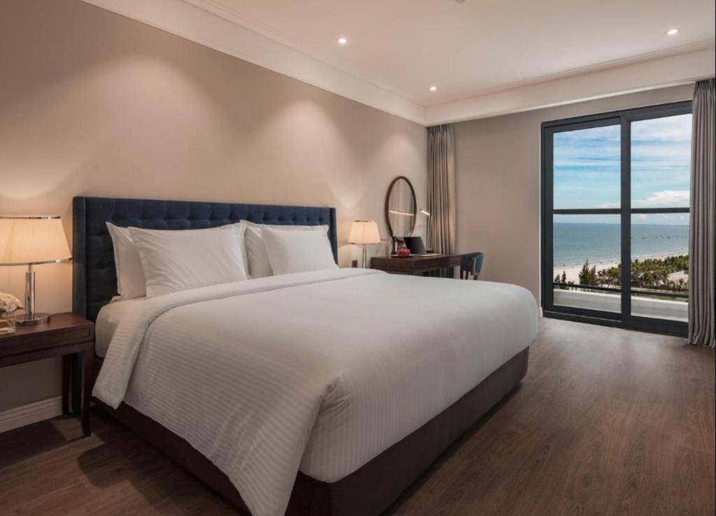 1 dormitorio con cama grande y ventana grande en Luxury Apartment in Sheraton Building with Ocean View en Da Nang