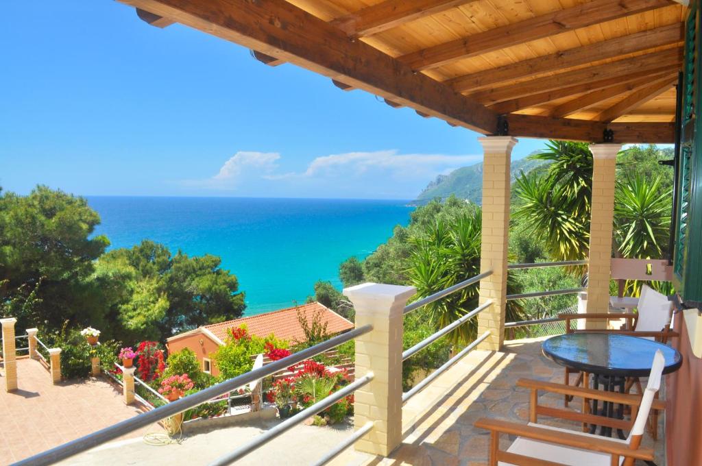 a balcony with a view of the ocean at Villa Takis on Pelekas beach Small house with garden and sea view in Pelekas