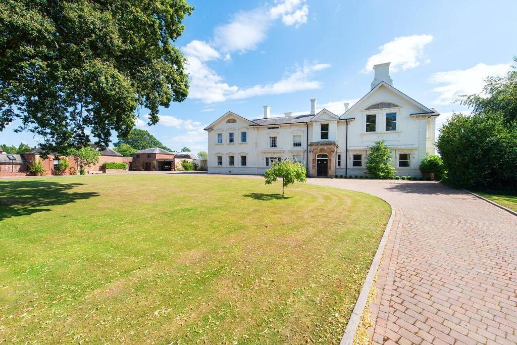 Severn Manor Country Estate في Astley: منزل أبيض كبير مع شجرة في الفناء