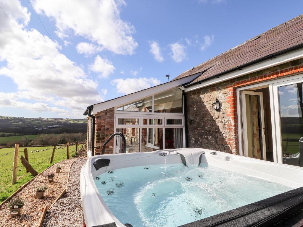 a hot tub in front of a house at Sewin Cottage in Carmarthen