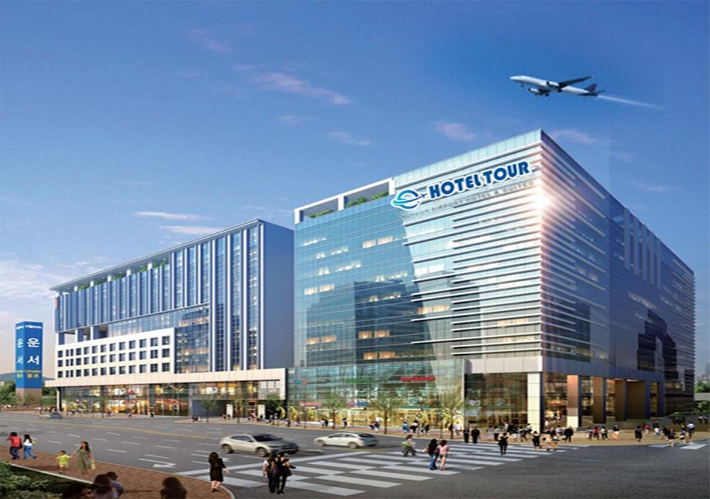 a large office building with a plane flying over it at Hotel Tour Incheon Airport Hotel & Suites in Incheon