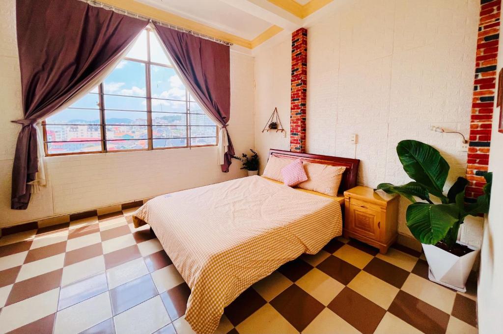 sypialnia z łóżkiem i dużym oknem w obiekcie Nụ Cười Xinh w mieście Da Lat