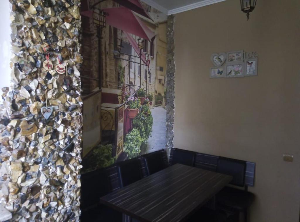 una sala da pranzo con tavolo e una parete con un dipinto di Апартаменты на Агрба 11/1 a Pizunda