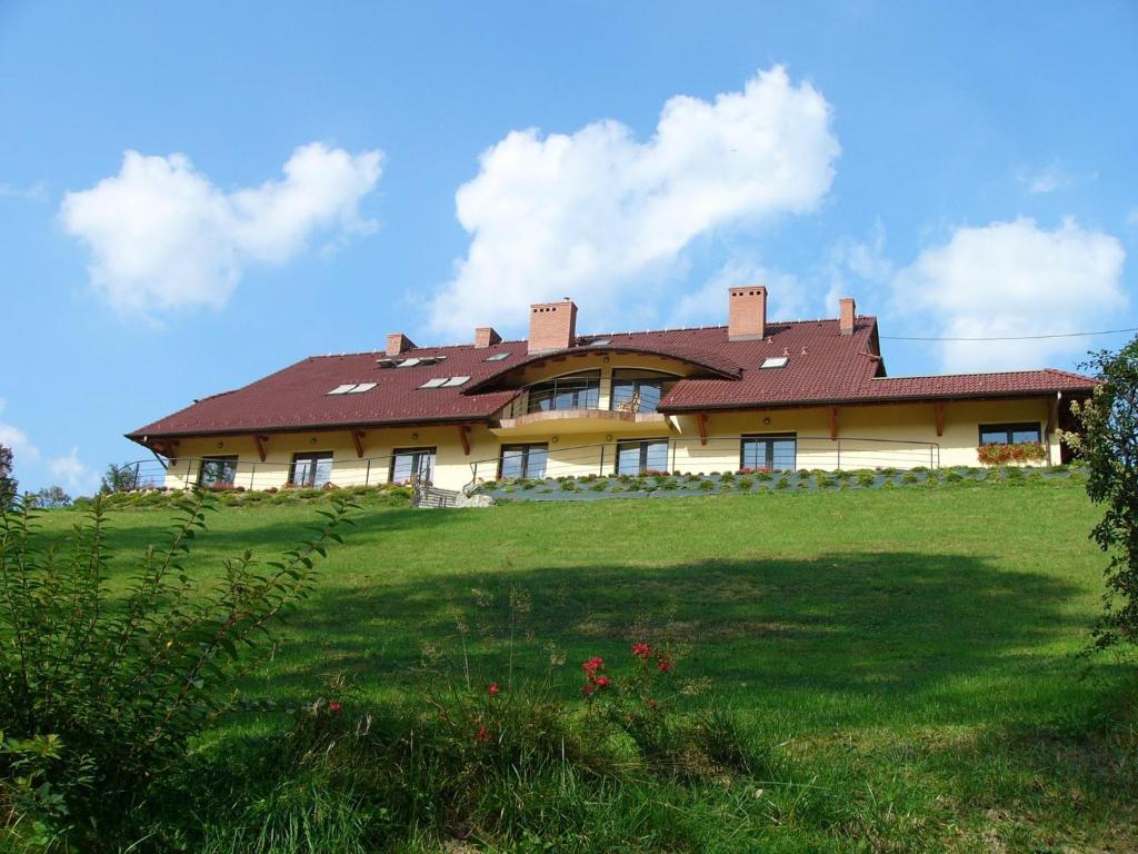 a large house on top of a green field at ZAGÓRZANKA Pensjonat Rehabilitacyjno-Rekreacyjny SiS Dziadkowiec - Spółka Jawna in Mszana Dolna