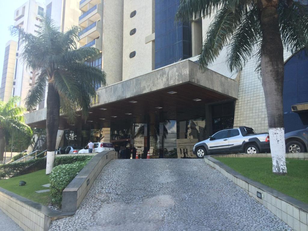uma rua em frente a um edifício com palmeiras em Mc Golden Flats no Recife