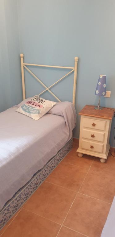 a bedroom with a bed and a wooden night stand at Apartamentos Atlanterra COSTA Y SOL in Zahara de los Atunes