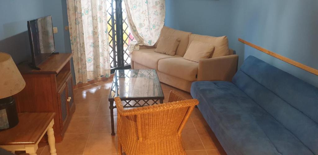 a living room with a couch and a table at Apartamentos Atlanterra COSTA Y SOL in Zahara de los Atunes