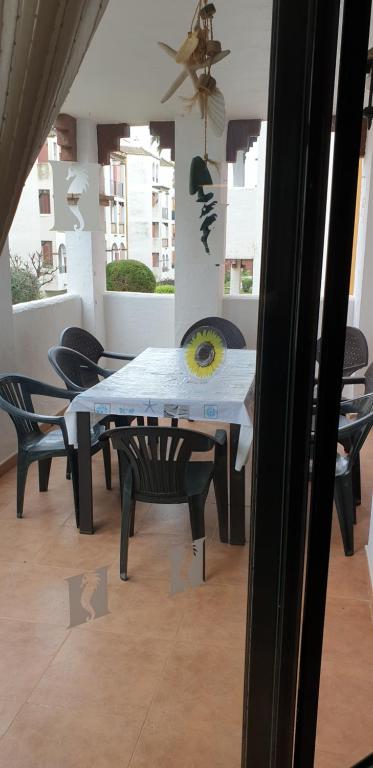 a dining table and chairs in a room with a ceiling at Apartamentos Atlanterra COSTA Y SOL in Zahara de los Atunes